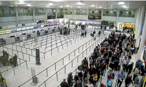  ??  ?? Passengers queue for flights at Gatwick Airport as the airport and airlines work to clear the backlog of flights delayed by a series of drone incidents earlier last week.