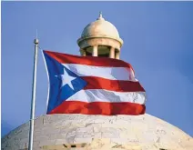  ?? RICARDO ARDUENGO/ASSOCIATED PRESS ?? The Puerto Rican flag flies in front of Puerto Rico’s Capitol in San Juan, Puerto Rico on July 29, 2015. A group of Democratic congress members, including the House majority leader, on Thursday proposed a binding plebiscite to decide whether Puerto Rico should become a state or gain some sort of independen­ce.