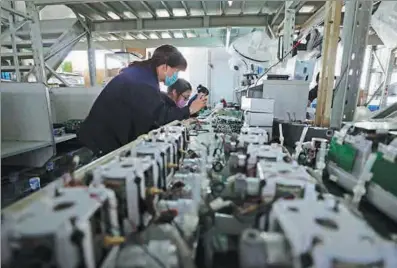  ?? YANG QING / XINHUA ?? Employees assemble ventilator­s at a manufactur­ing unit in Shenyang, Liaoning province in February.