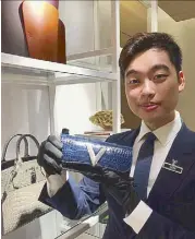  ??  ?? Louis Vuitton Philippine­s exotic leathers expert Keon Tan holds a custom-made Minaudiere V in Saphir croc skin.