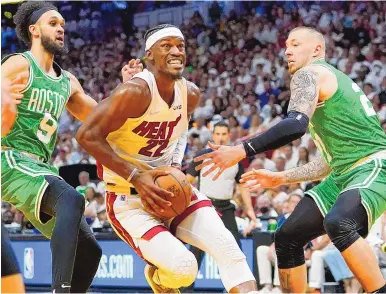  ?? LYNNE SLADKY/ASSOCIATED PRESS ?? Miami forward Jimmy Butler (22), who scored 41 points, drives to the basket between Boston guard Derrick White (9) and center Daniel Theis during the second half of Game 1 of the Eastern Conference finals on Tuesday night in Miami.