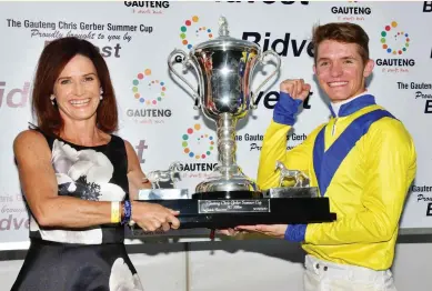  ?? Picture JC Photograph­ics ?? HAPPY DAY. Apprentice Denis Schwarz receives the trophy from Bridget Gerber, wife of the late Chris Gerber, after winning the Gauteng Chris Gerber Summer Cup, proudly brought to you by Bidvest, aboard Zillzaal. See Back Page