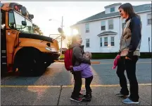  ?? SARAH GORDON/THE DAY ?? Hadley, 2, hugs her brother Colton, 6, as their mom, Kelsey Smith, looks on while he gets off the school bus on Nov. 8, 2017, in Groton. Hadley gives Colton a hug every morning when he goes to school and every afternoon when he gets back and is upset...