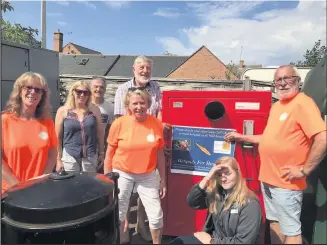  ??  ?? ■ The Big Red Bin with Helipads for Hospital founder John Nowell standing next to it, alongside members of the Barrow Footpaths Group and a member of staff from the Co-op.
