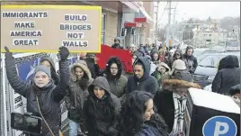  ?? AP photo ?? People march down Broadway Avenue in Pittsburgh’s Beechview Avenue protesting the recent crackdowns on immigrants ordered by U. S. President Donald Trump during a “Day Without Immigrants” protest.