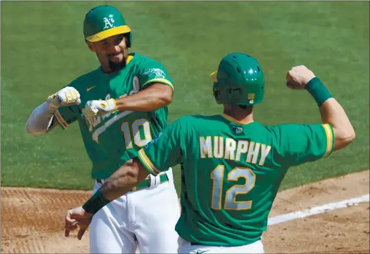  ?? PHOTOS BY RAY CHAVEZ — STAFF PHOTOGRAPH­ER ?? The Athletics’ Sean Murphy, right, welcomes home Marcus Semien as they celebrate his two-run homer against the White Sox in the second inning of Game 2 in Oakland.