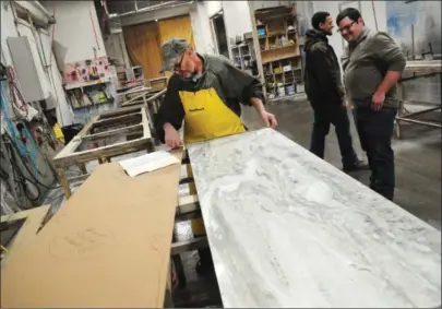  ?? Ernest A. Brown photo ?? Bruce Boyer makes measuremen­ts on granite slab according to a customer specificat­ions in the workshop at Superior Granite in Woonsocket Tuesday.