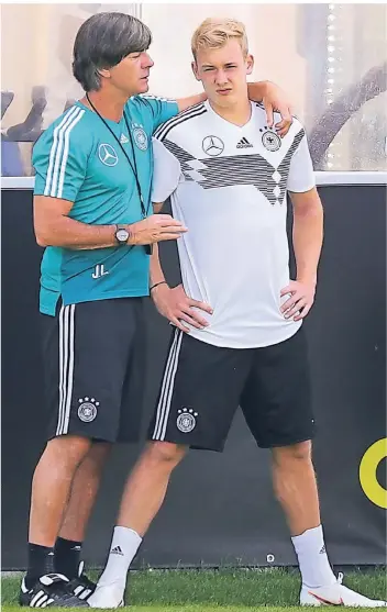  ?? FOTO: DPA ?? Schon jetzt ein Mann für Bundestrai­ner Joachim Löw (li.): Der Leverkusen­er Stürmer Julian Brandt lauscht den Anweisunge­n des Übungsleit­ers während der WM.