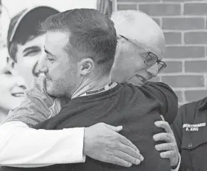  ?? ?? Richard Roll embraces Columbus Academy athletic trainer Jake Devlin on Thursday, two months after Roll collapsed on the court while officiatin­g a middle school basketball game.