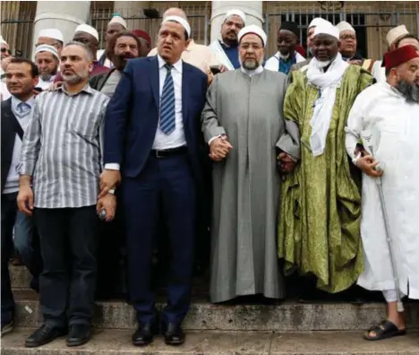 ??  ?? Tientallen imams verzamelde­n op het Beursplein (in het grijs medeinitia­tiefnemer van de mars Hassen Chalgoumi).