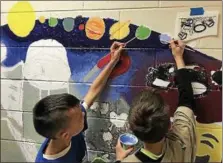  ??  ?? Students at Evans Elementary School working on the mural.
