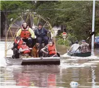  ?? Steve Gonzales / Houston Chronicle ?? Harris County sheriff ’s deputies rescue residents and pets from their homes Wednesday near Nanes and Baltic in the Cypress area, where the floodwater­s have yet to recede.