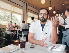  ??  ?? Left, owner-chef Alon Shaya at Saba in New Orleans discusses his mission to help change restaurant culture, starting with his own. Right, sous chef Julia Henner and line cook Jack Cole work in the kitchen together at Saba. About 60 per cent of the restaurant’s staff is women.