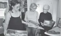  ??  ?? A collection of paintings by Hattie B. Fox put out for display are viewed by the artist’s great-great-granddaugh­ter Velicity Smith, from left, Dartmouth fibre artist Linda Tremblay and Betty June Smith, the artist’s granddaugh­ter.