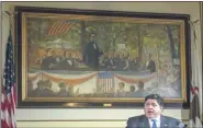  ?? JUSTIN L. FOWLER — THE STATE JOURNAL-REGISTER VIA AP ?? In this May 22, 2020 file photo, Illinois Gov. JB Pritzker answers questions from the media, from his office at the Illinois State Capitol, in Springfiel­d, Ill., in front of a painting depicting a political debate in Charleston, Ill., on Sept. 18, 1858, between Stephen A. Douglas and Abraham Lincoln.