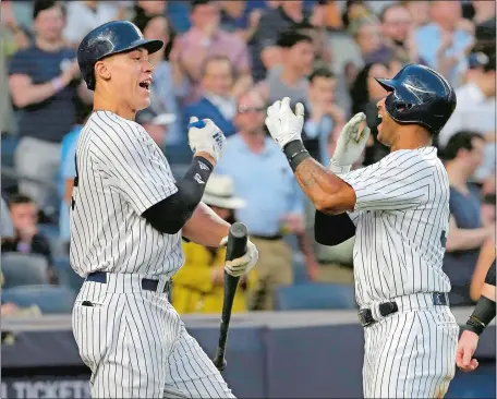  ?? SETH WENIG/AP PHOTO ?? Aaron Hicks, right, celebrates his two-run home run with Aaron Judge during the fifth inning of Tuesday night’s game at Yankee Stadium in the Bronx, where the Yankees hit four home runs en route to a 7-2 victory over the Seattle Mariners.