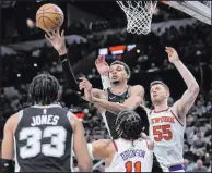  ?? Eric Gay The Associated Press ?? Spurs center Victor Wembanyama passes the ball over Knicks guard Jalen Brunson during San Antonio’s 130-126 overtime win Friday.