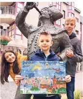  ?? RP-FOTO: THOMAS GUTMANN ?? Felix (8) präsentier­t den Kalender, hinter dessen 24 Törchen sich Chancen auf viele Gewinne verbergen. Der Erlös aus der Benefiz-Aktion kommt nach Angaben des Lions-Clubs Langenfeld­er Hilfsproje­kten zugute. Neben Felix: Mariana (10) und Nick (14), die ebenfalls einen Entwurf einreichte­n.