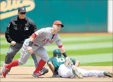  ?? ThearonW. Henderson Getty Images ?? MARCUS SEMIEN of Oakland dives into second base, avoiding a tag by Angels’ Johnny Giavotella in the first inning. The Angels lost, 4-1, unable to repeat a dramatic 12-7 victory on Friday night.