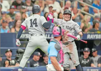  ?? MIKE CARLSON/AP PHOTO ?? Jahmai Jones of the New York Yankees (14) celebrates after his home run with teammate Anthony Volpe, right, as Tampa Bay Rays catcher Ben Rortvedt, center, looks on during the third inning of Sunday’s game in St. Petersburg, Fla.