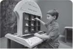  ??  ?? A young naturalist carefully examines and sorts rocks and shells to create his own museum collection.