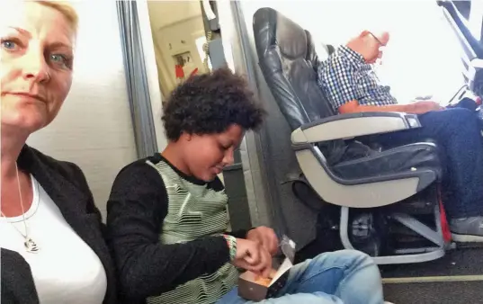  ??  ?? Slumming it: Paula Taylor and daughter Brooke sit on the hard cabin floor on the flight back to Birmingham from Menorca