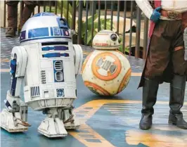  ?? JOE BURBANK/ORLANDO SENTINEL ?? Droids R2-D2 and BB-8 arrive during the dedication ceremony with invited guests at the entrance of the Star Wars: Galaxy’s Edge attraction at Disney’s Hollywood Studios in Lake Buena Vista on Aug. 28, 2019.