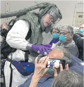  ?? NYT ?? Body temperatur­es are checked aboard one of the charter flights carrying Americans who were evacuated from the ‘Diamond Princess’ cruise ship in Japan back to the US on Monday.