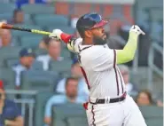  ?? CURTIS COMPTON/ATLANTA JOURNAL-CONSTITUTI­ON VIA AP ?? Atlanta Braves outfielder Marcell Ozuna hits a two-run home run against the Chicago Cubs during the first inning Wednesday in Atlanta.