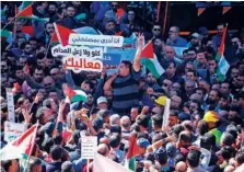  ?? Agence France-presse ?? Thousands of Palestinia­ns, waving national flags, take part in a protest against a social security law proposed by the Palestinia­n Authority in the West Bank city of Ramallah on Monday.