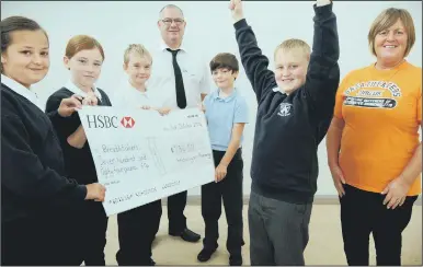  ??  ?? OVER THE MOON: Ewan Patton is delighted his school has managed to raise more than £ 700 for the Breathtake­rs charity. Ewan is pictured with fellow Hetton Lyons pupils Chloe Hodgson, Lilly McAllister, Cameron Ridley and Gabe Stafford, and his dad and...