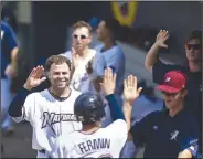  ?? NWA Democrat-Gazette/CHARLIE KAIJO ?? Northwest Arkansas Naturals players congratula­te catcher Freddy Fermin (38) after a score during a baseball game Monday at Arvest Ballpark in Springdale.