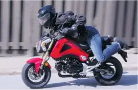  ?? Postmedia News ?? David Booth rides the 2014 Honda Grom.