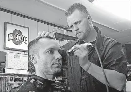  ?? [JIM SIEGEL/DISPATCH] ?? Tony Good, giving a haircut in downtown Obetz to Kevin Groom, likes President Trump’s use of military force but worries that he could lose his health insurance through Obamacare.