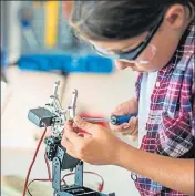  ?? GETTY IMAGES ?? A student fixing a robot arm in a workshop.