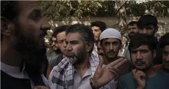  ?? AP ?? RESOURCES, NOT RECOGNITIO­N: A member of the Taliban, left, talks to Afghans gathering outside a government passport office recently re-opened on Oct. 6.