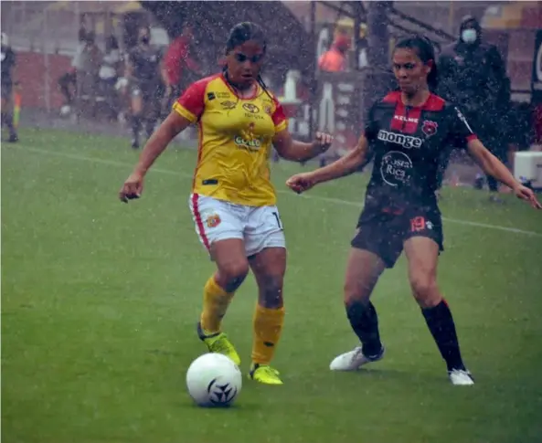  ?? Prensa Herediano ?? Melody Guerrero, de Herediano, y Valery Sandoval, de Alajuelens­e, en medio de un aguacero durante la primera mitad.