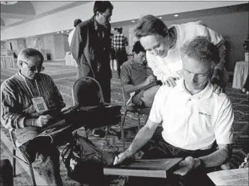  ?? Ann E. Yow-Dyson Getty Images ?? ESTHER DYSON of EDventure Holdings looks over the shoulder of Apple’s Larry Tesler in February 1992 as he uses an early tablet computer at the annual PC Forum in Tucson. Tesler joined Apple in 1980.