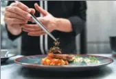  ?? LILLIAN SUWANRUMPH­A / AGENCE FRANCE-PRESSE ?? Edible winged ants are placed on a fish fillet inside the kitchen of Insects in the Backyard, which says it offers the first insect-based fine-dining menu in Bangkok, on Aug 15. Ratta Bussakornn­un, a 27-year-old diner after eating bamboo worms and a...