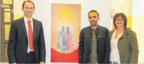  ?? FOTO: PRIVAT ?? Künstler Faisal Adil präsentier­t zusammen mit Frank Vögtle, Regionaldi­rektor der Landesbank Kreisspark­asse, und Sanja Mühlhauser vom Caritasver­band seine Kunstwerke