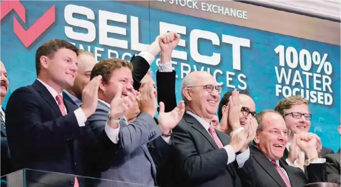  ??  ?? NEW YORK: Select Energy Services Chairman & CEO John Schmitz, foreground right, and company executives and guests celebrate their IPO as they ring the New York Stock Exchange opening bell yesterday. —AP