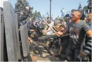  ?? Efrem Lukatsky / Associated Press ?? Protesters clash with police in Kiev after a vote gave greater powers to the rebel-held east.