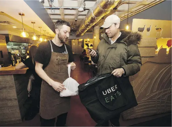  ?? DAVID BLOOM ?? An Uber Eats driver picks up an order from Prairie Noodle Shop on a recent Friday night.