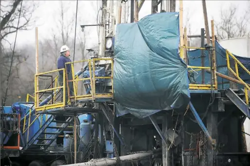  ?? Michael Henninger/Post-Gazette ?? Harold Westfall of Barber County, W.V., checks an instrument on a Rice Energy Marcellus Shale drilling rig in Lone Pine, Washington County, in 2011.