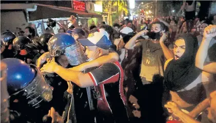  ?? AP ?? Amigos. Un manifestan­te abraza al policía para expresar que los une el mismo reclamo contra el gobierno.