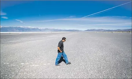  ?? Allen J. Schaben Los Angeles Times ?? PHILLIP KIDDOO, air pollution control officer for the Great Basin air district, walks across salt and fine sand at Mono Lake’s shoreline.