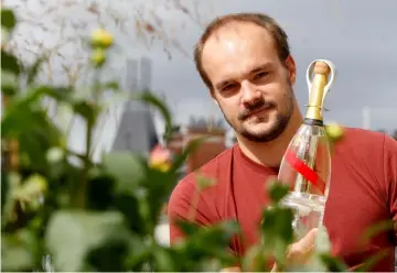  ??  ?? French Interior designer Octave de Gaulle poses with a bottle of Mumm Grand Cordon Stellar champagne that he designed.