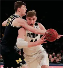  ?? AP/JULIE JACOBSON ?? Purdue center Isaac Haas (right) attempts to get around Michigan center Jon Teske during the first half of the Big Ten Tournament championsh­ip game Sunday in New York. Michigan won 75-66 for its second consecutiv­e tournament title.