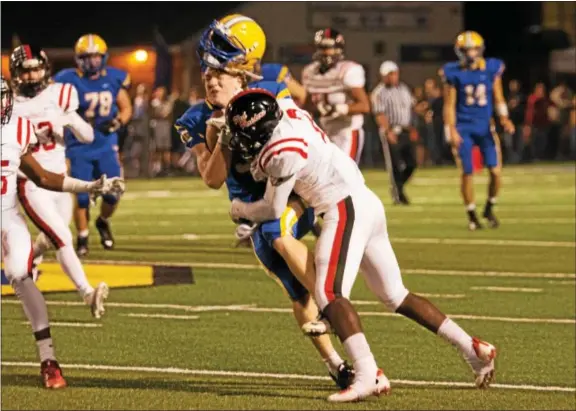  ?? MICHAEL REEVES — FOR DIGITAL FIRST MEDIA ?? Downigntow­n East’s Connor Noble gets hit by Coatesvill­e’s Kahtero Summers in Friday’s game at Kottmeyer Stadium.