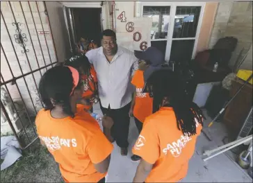  ?? The Associated Press ?? HOUSTON PRAYERS: In this Nov. 17 photo, homeowner George Dorsey, center, prays with Samaritan’s Purse volunteers who are helping to rebuild his hurricane-damaged home in Houston. How is Texas spending billions in federal aid in response to Harvey,...